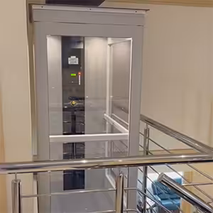 Modern iconic home elevator near staircase railing