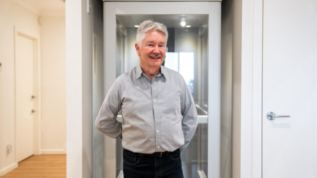 Man standing and smiling in front of a newly installed iconic home lift