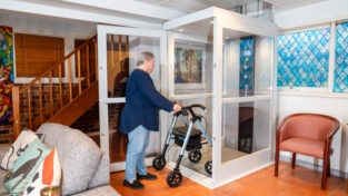 Elderly woman testing the iconic home lift inside a residential home