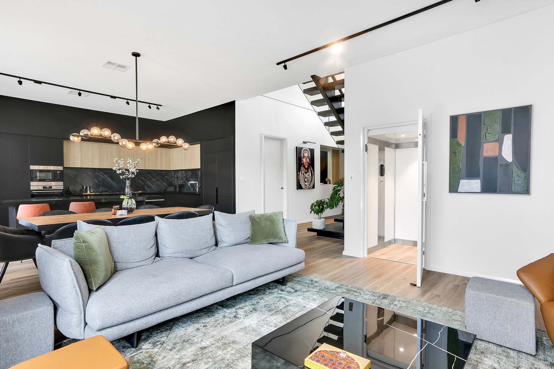 Modern open-plan living room with kitchen and Australian made home lift.