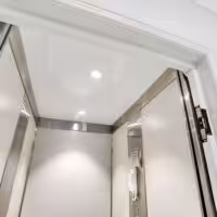 Interior of modern compass home lift with lights on.