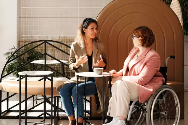 Two women discussing over coffee in a cafe.